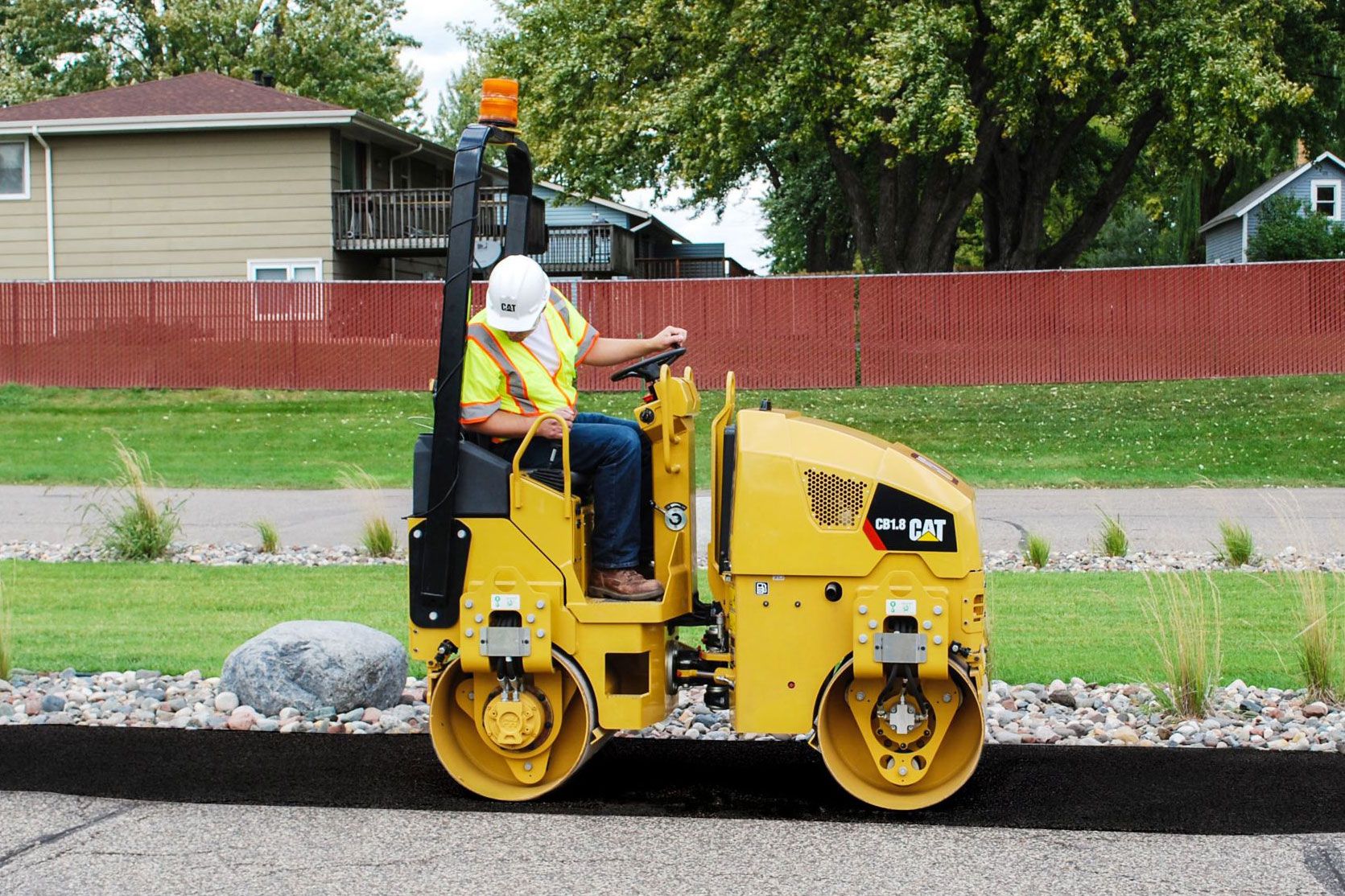 Compactador de servicios pavimentando una nueva calle en una calle residencial