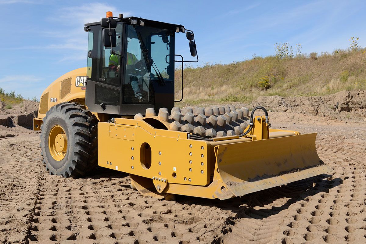 El compactador de suelo vibratorio Cat en funcionamiento en un campo de barro