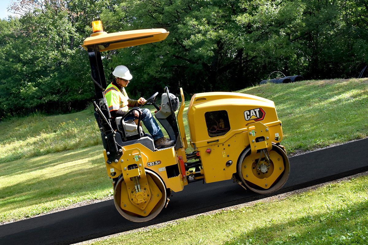 Compactador de servicios públicos subiendo una nueva carretera