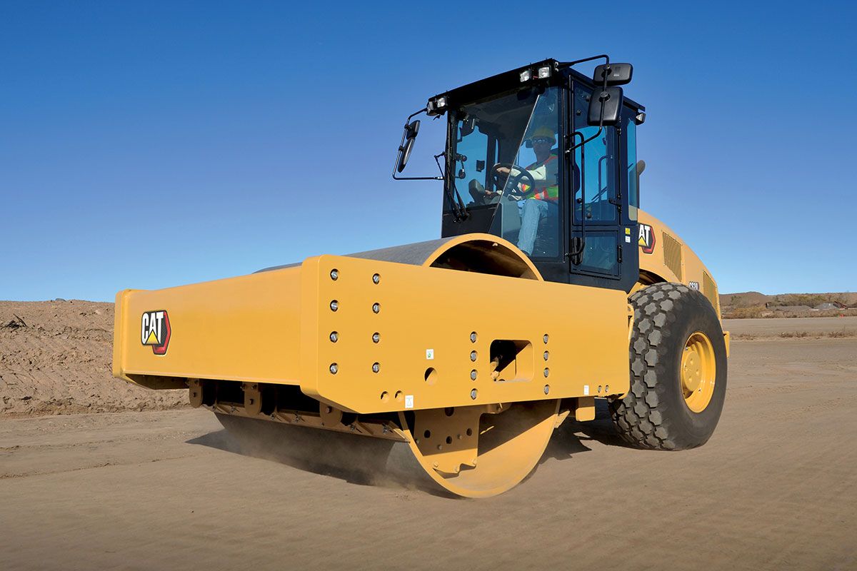 Un compactador de suelo vibratorio avanzando por un camino de tierra