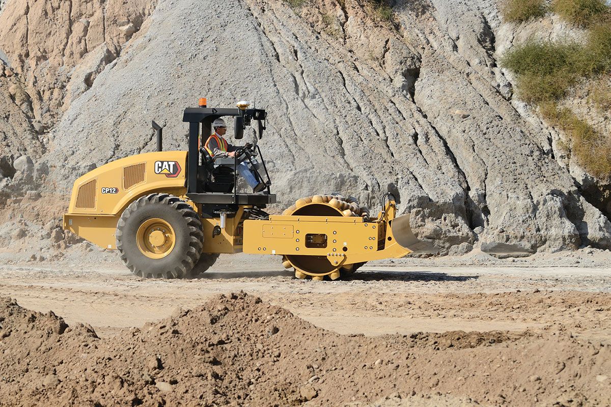 Un compactador de suelo vibratorio trabajando en un camino de tierra