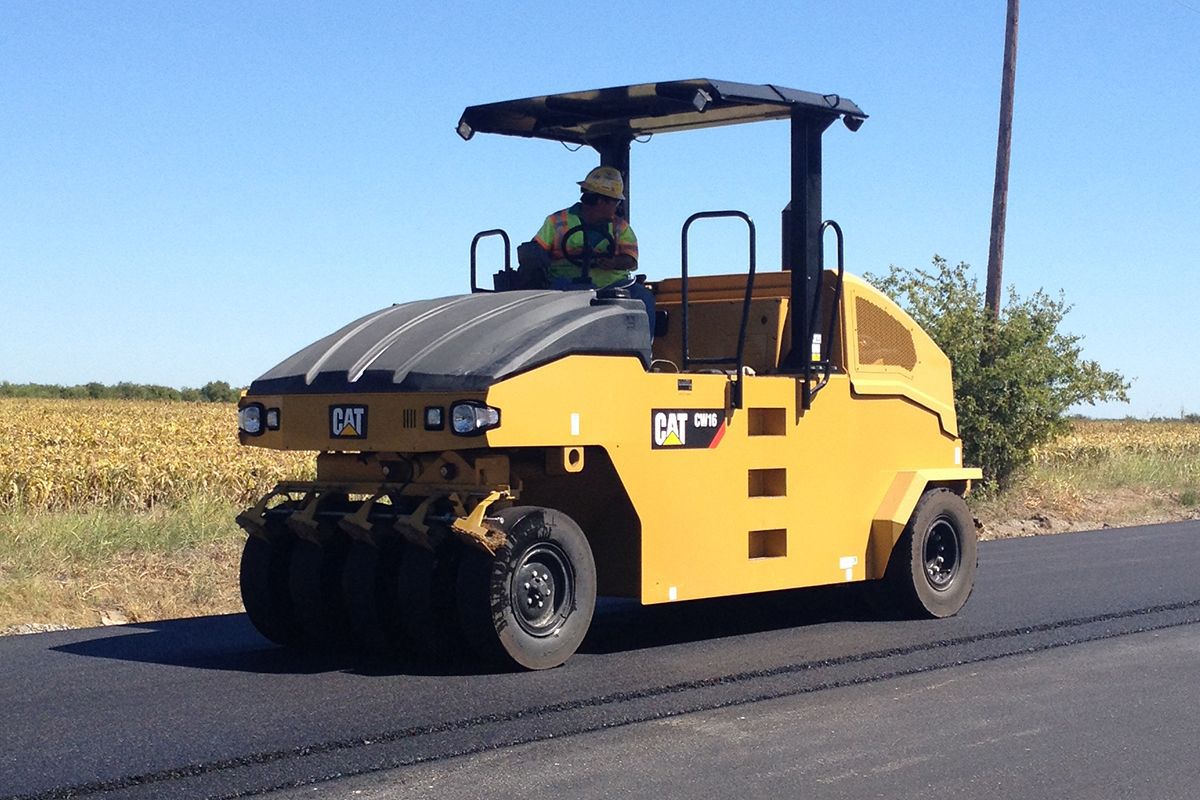 Rodillos neumáticos pasando sobre la carretera pavimentada