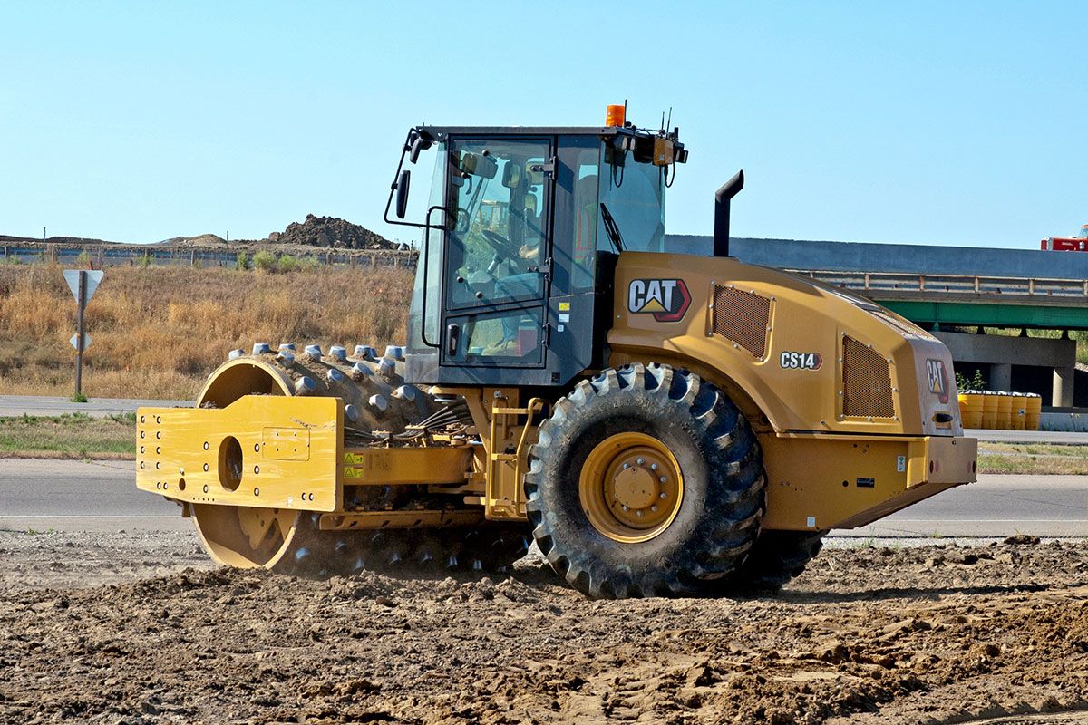 Una toma de un compactador de suelo vibratorio CS14 trabajando en la tierra.