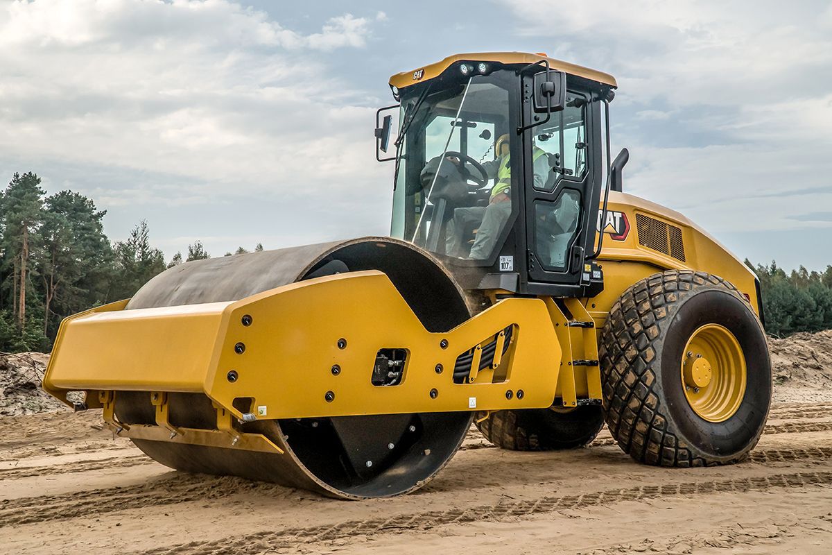 Hombre en compactador de suelo vibratorio Caterpillar