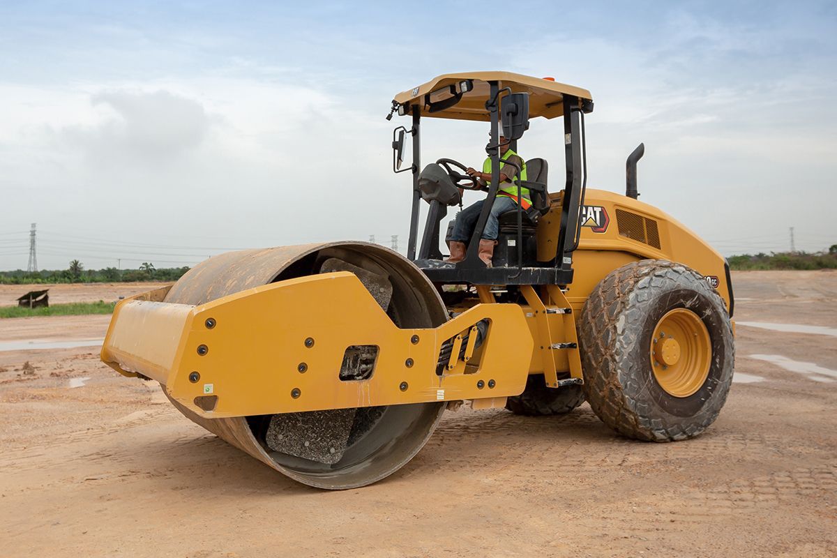 Hombre en compactador de suelo vibratorio Caterpillar