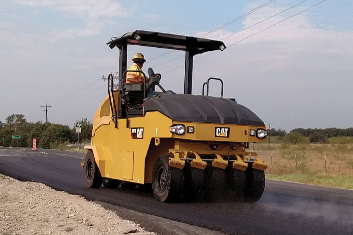 Rodillos neumáticos pasando sobre la carretera pavimentada