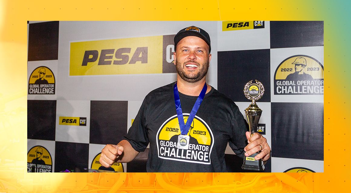 Gilberto Scheidt wearing a Global Operator Challenge teeshirt smiling and holding a trophy