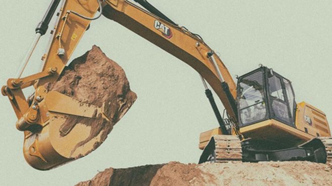 excavator on site digging up some dirt
