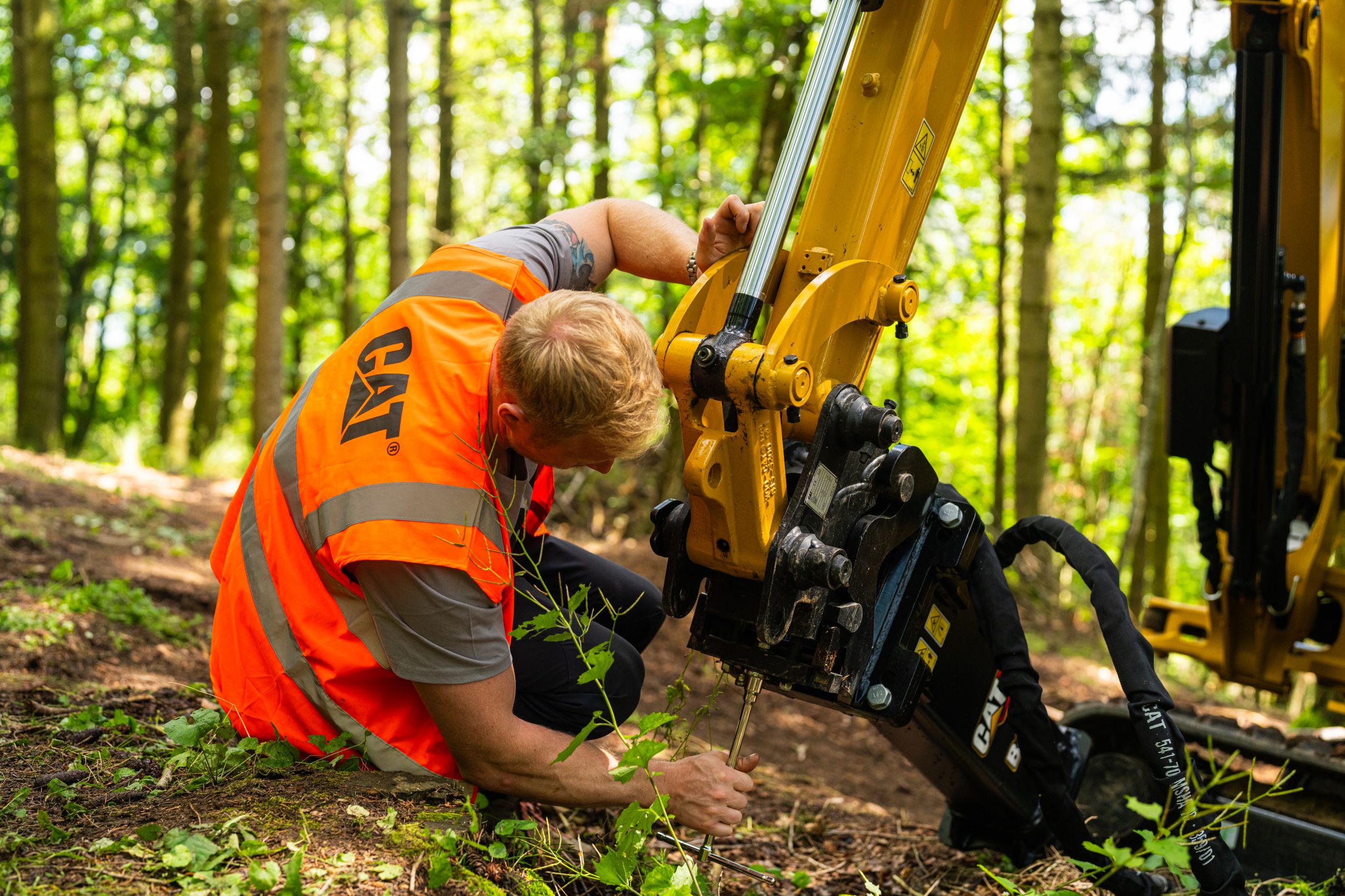 Opérateur changeant l'équipement de sa minipelle