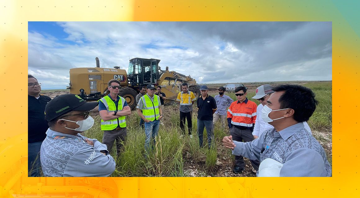 Group of people meeting in front of Cat equipment