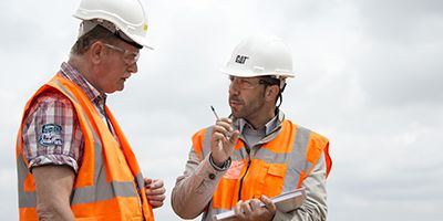 hommes parlant avec une planchette à pince