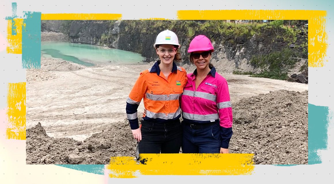 Two women smiling and posing on a job site