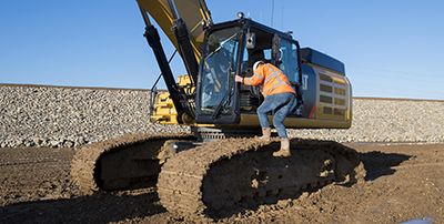 Man climbing steps into machine cab