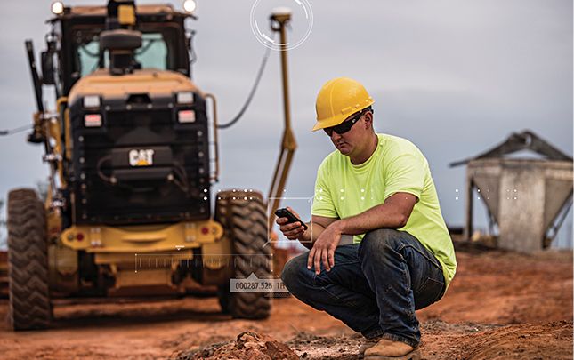 Trabajador de la construcción en el lugar con teléfono