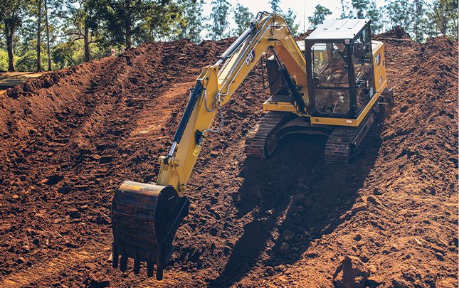 Miniescavadeira Cat® 307 with a bucket attachment digging