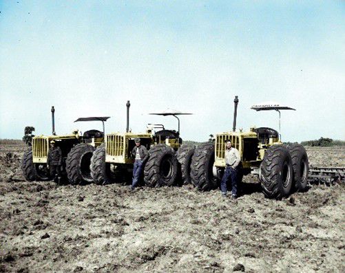 Three Caterpillar D6s with wheels in a field, 1955.