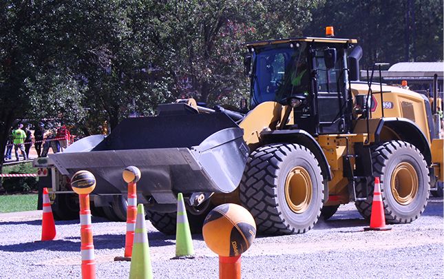 Cargadora de ruedas que opera alrededor de conos con bolas equilibradas sobre ellos