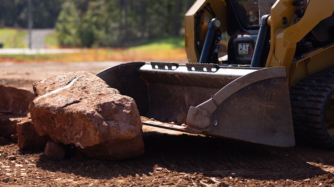 Excavator dumping dirt with ground engaging tool system on bucket