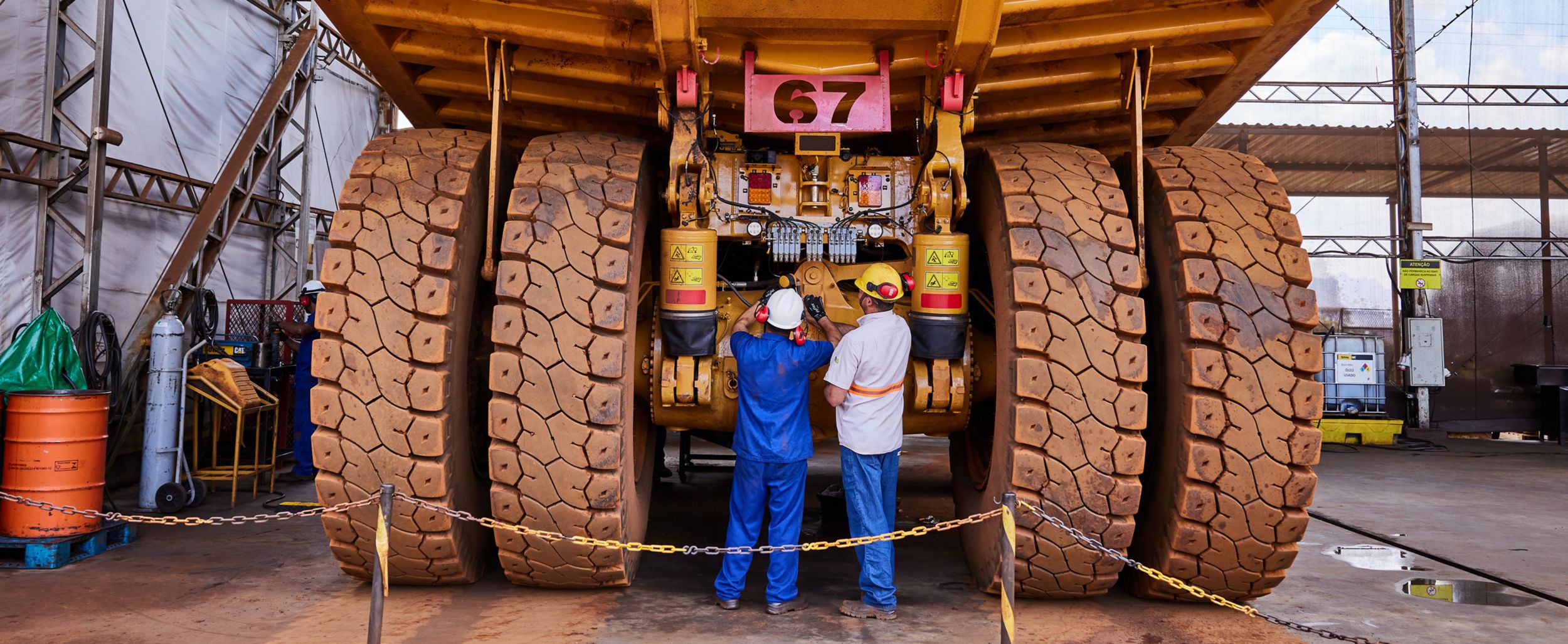 Two men consulting in front of a Cat Mining machine