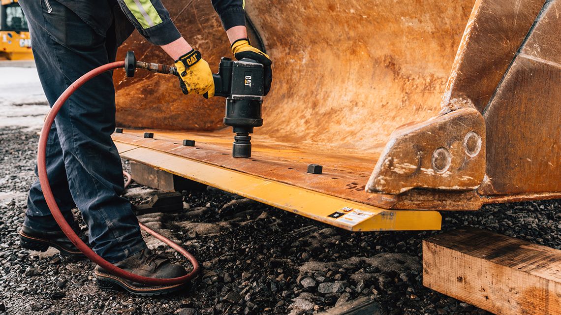 close up of someone using a Cat tool on Cat equipment