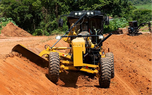 Motoniveladora empujando montón de tierra