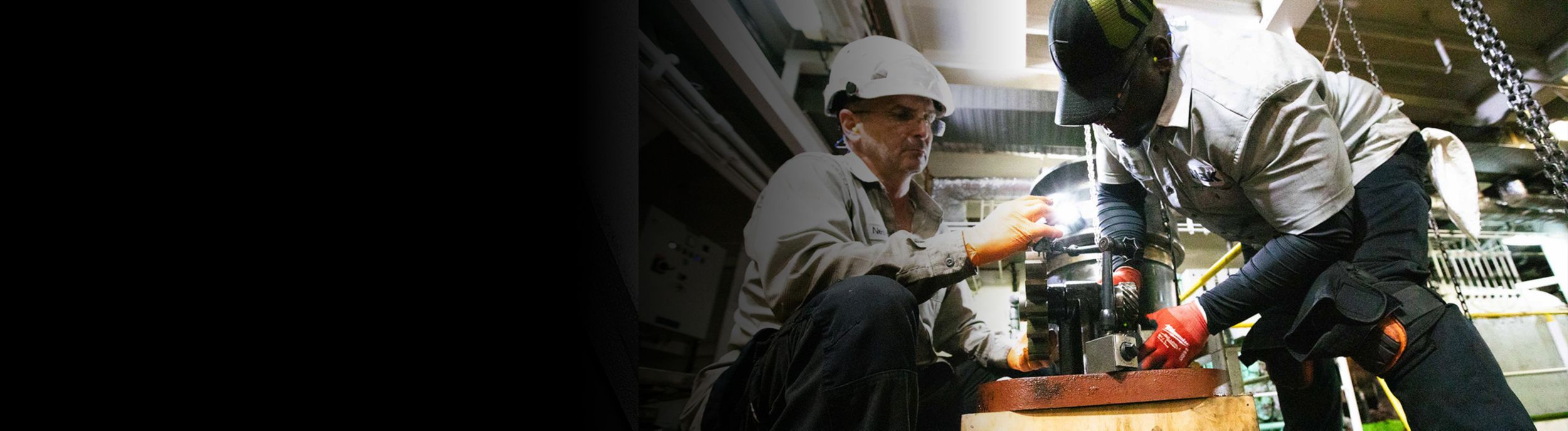 Two employees working on an MaK engine