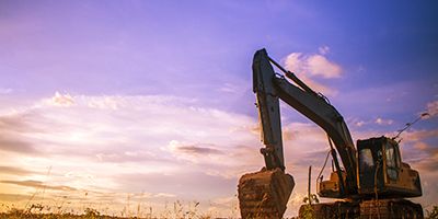 Excavator in front of sunset