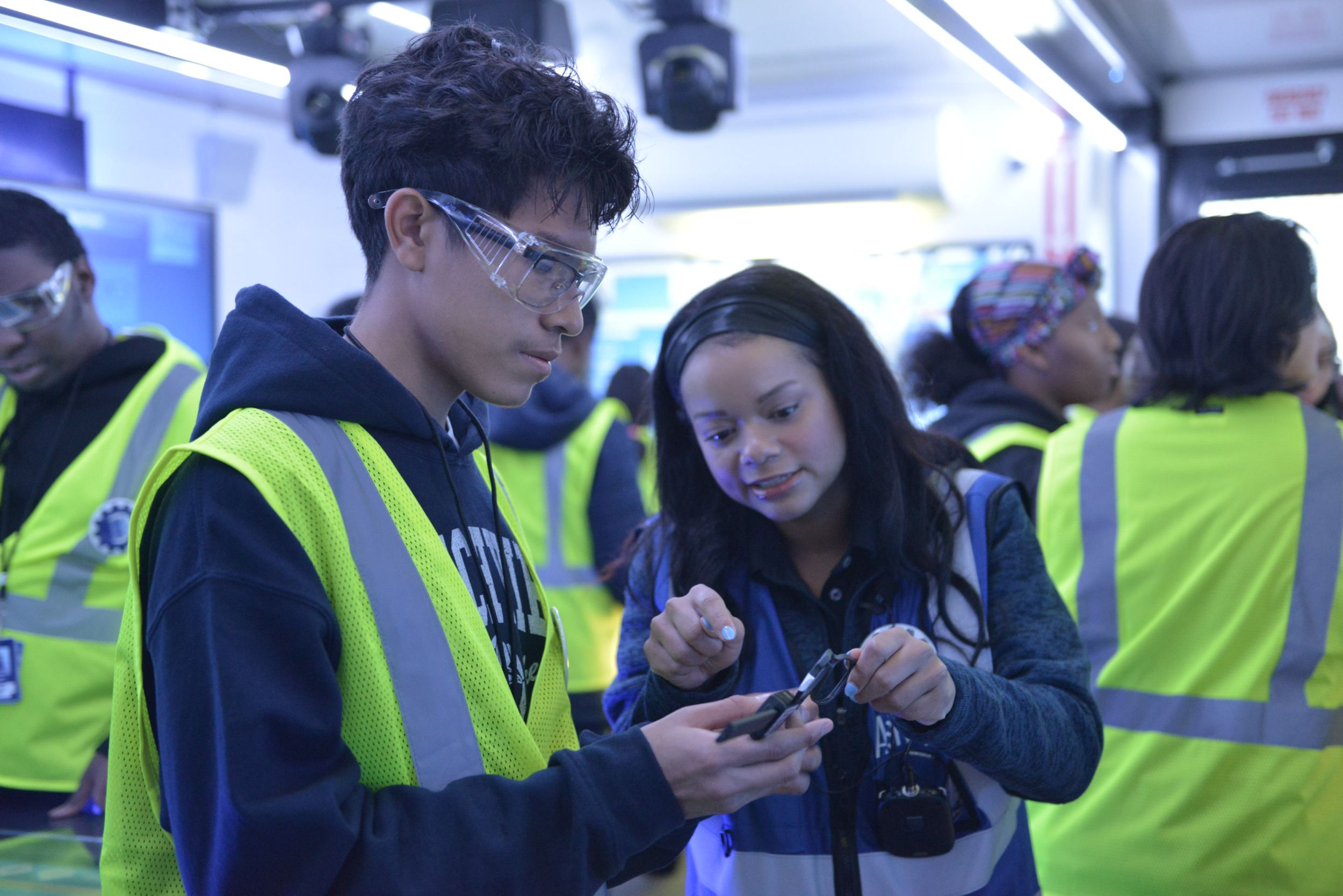 two students in safety vest looking at vest