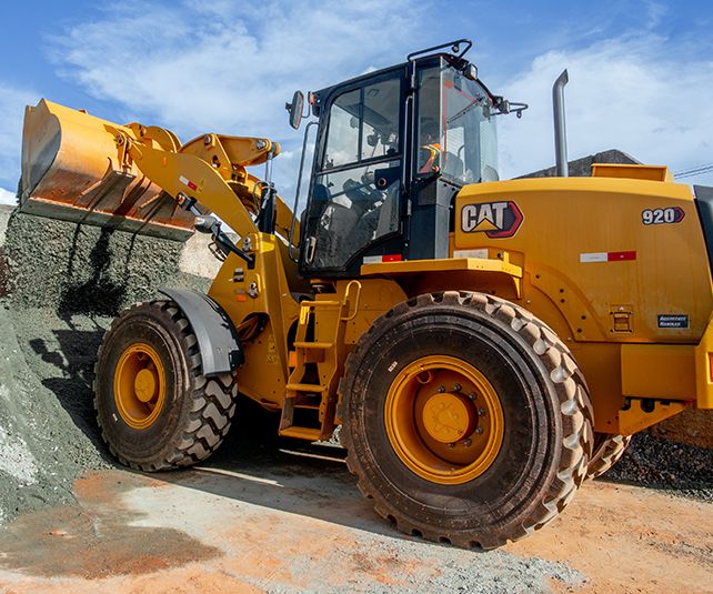 Cargadoras compactas Cat® vertiendo rocas desde la cuchara.