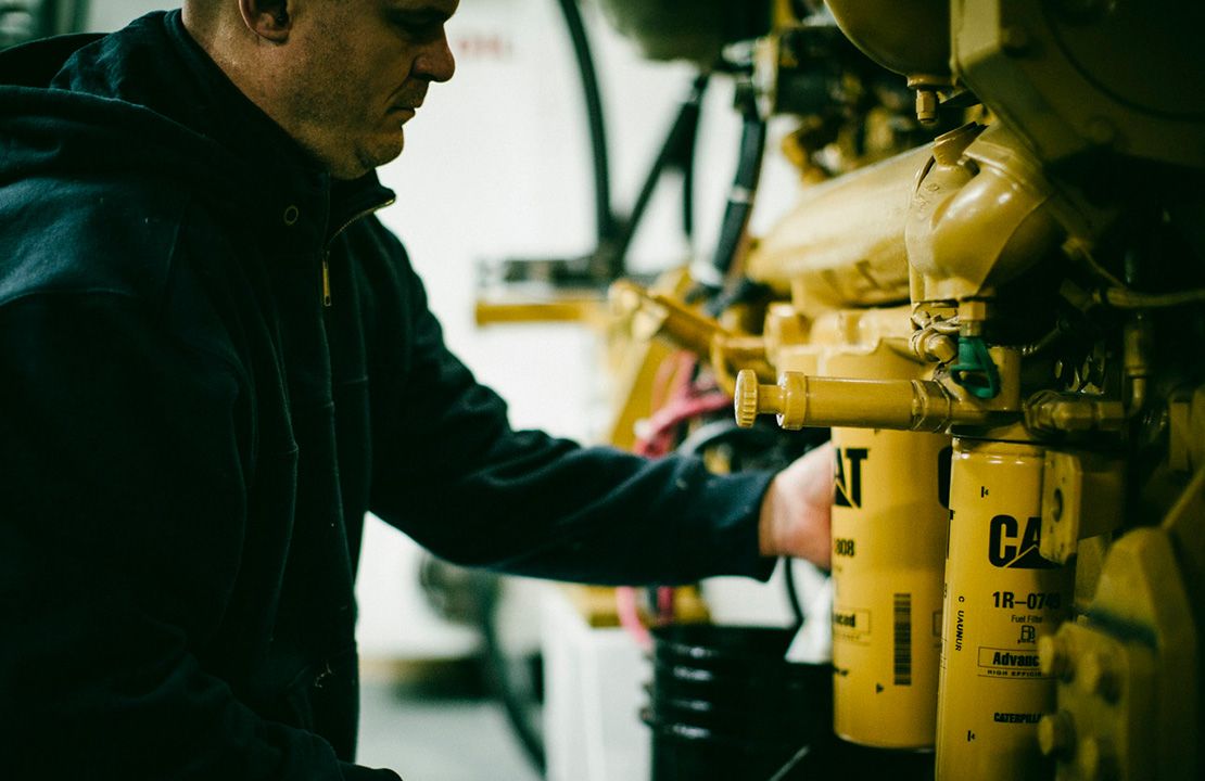 Person changing Cat filter on an engine