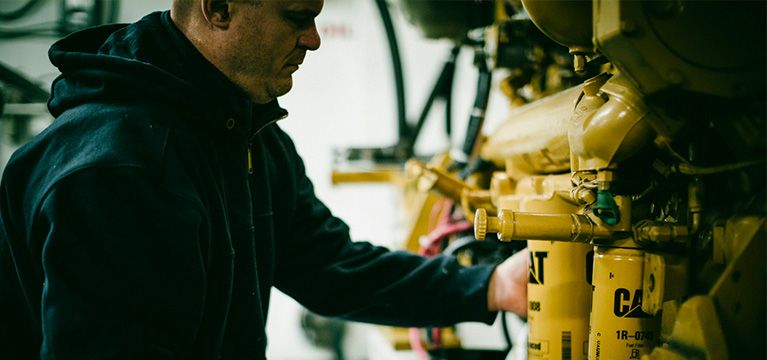 Person changing Cat filter on an engine