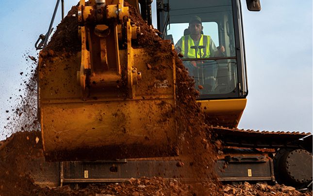 Operador escavando terra com uma escavadeira