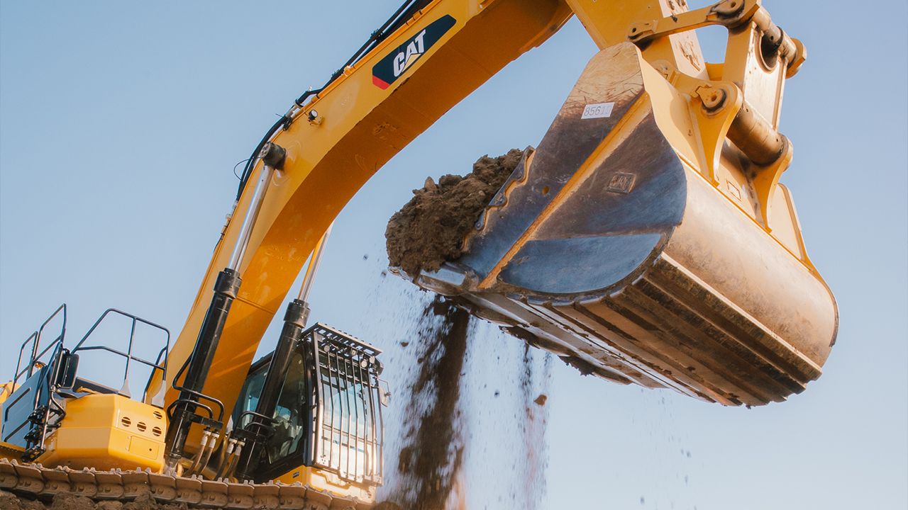 Excavator dumping dirt on a job site