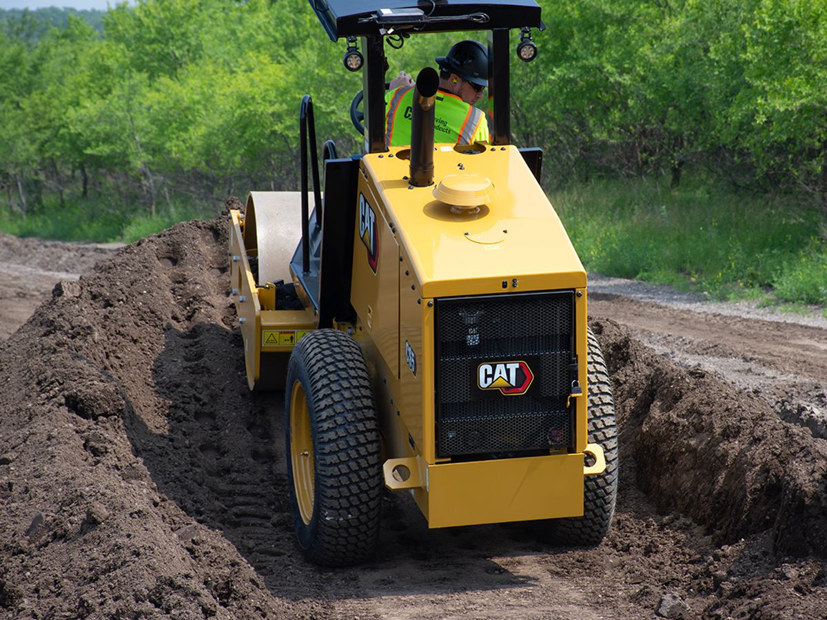 Cat CS5 vibratory soil compactor operating on an incline