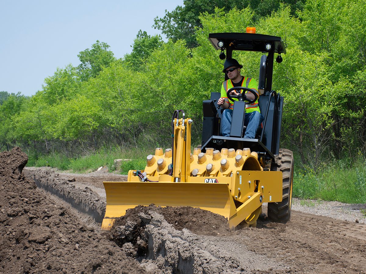 Cat CP5 vibratory soil compactor operating on an incline