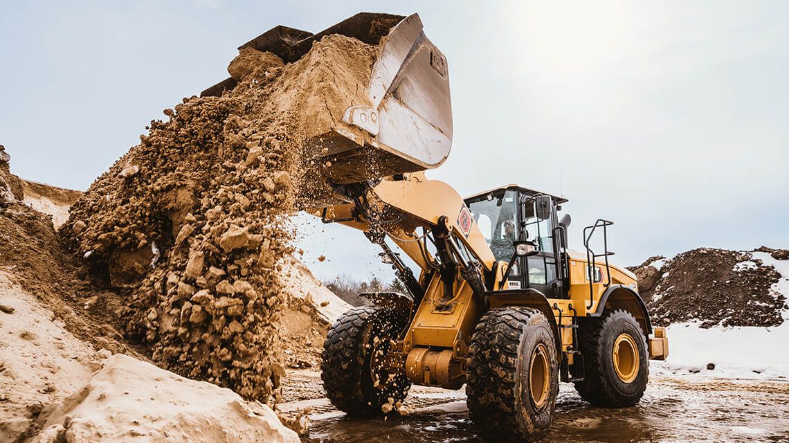 Cat tractor dumping dirt onto pile