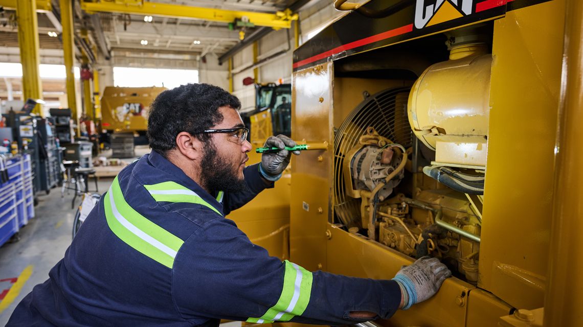a technician shining a light into a machine
