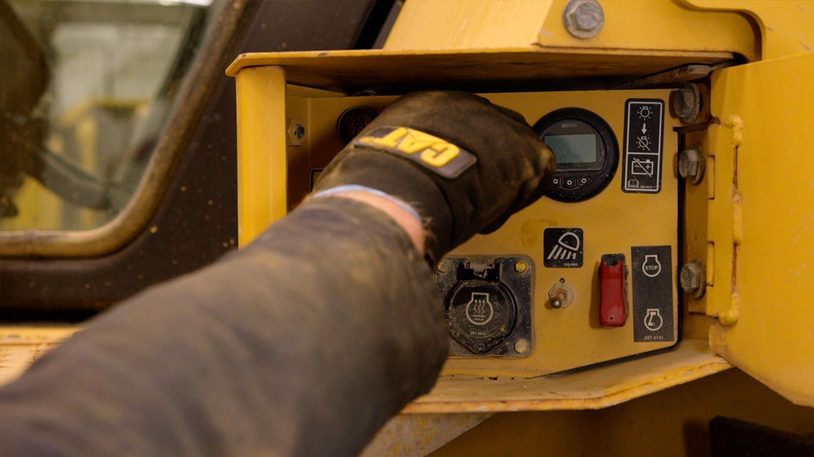 technician adjusting a knob on a panel