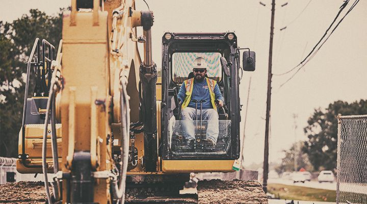 Man operating cat crane on a road site
