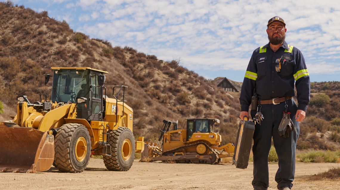 operator on a jobsite; 2 machines in the background
