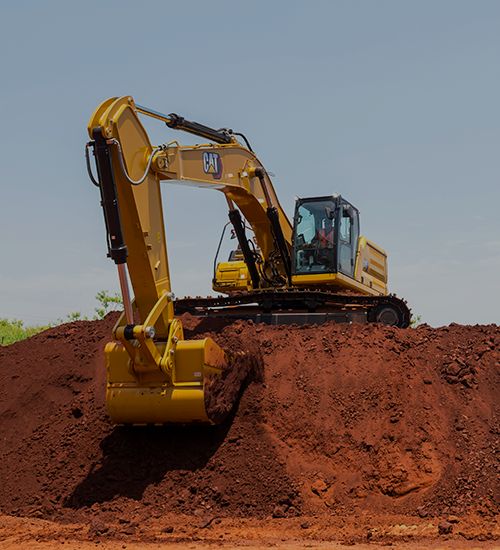Una excavadora recogiendo tierra de un gran montón