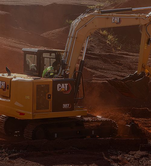 Miniescavadeira despejando terra da caçamba