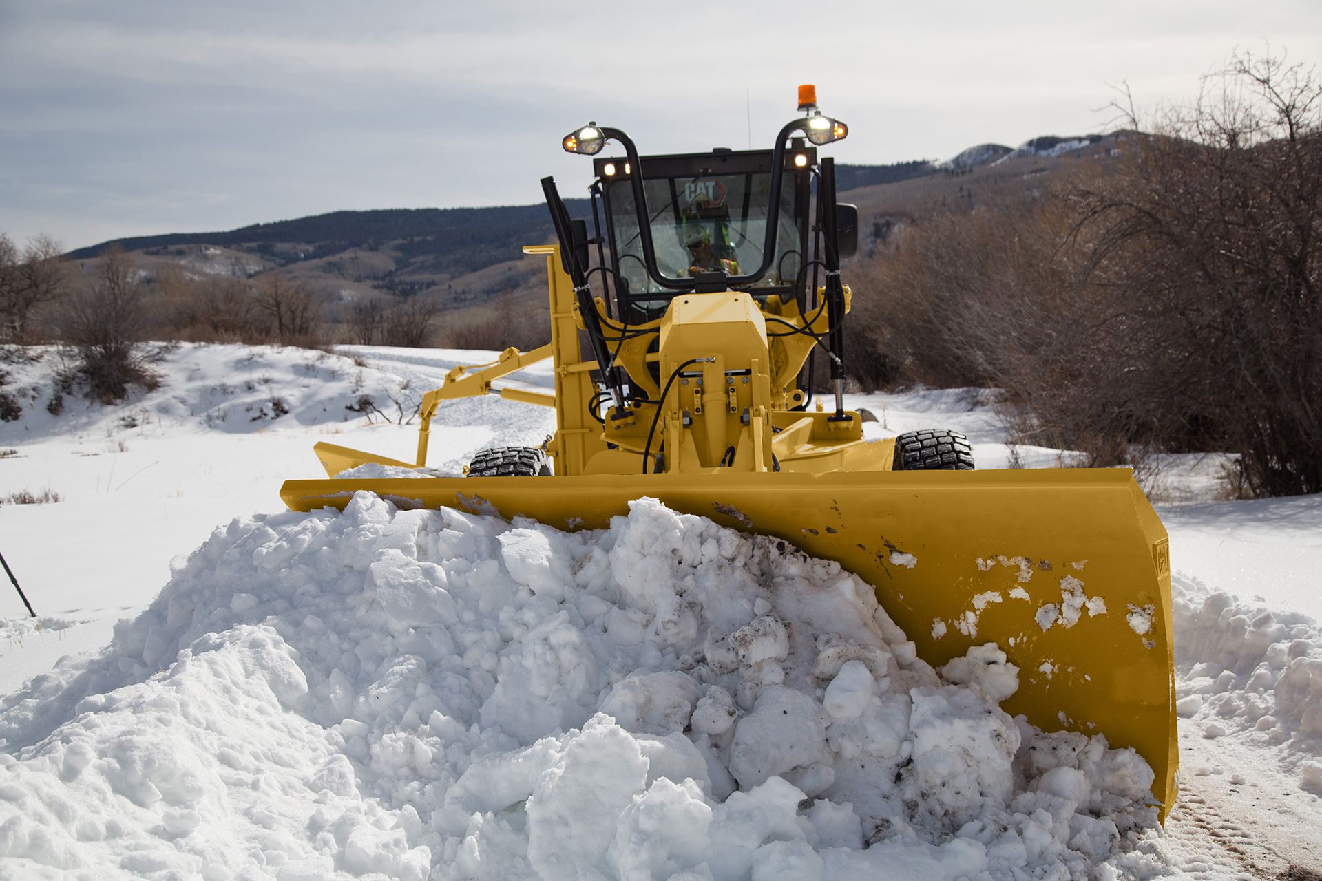 Incluso en terrenos difíciles como la nieve, tu motoniveladora mantiene el control.