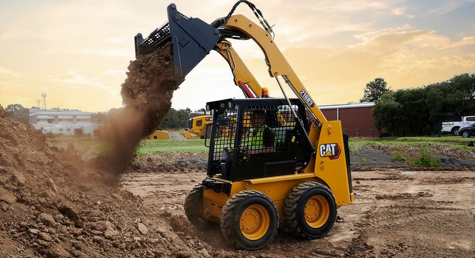 Skid steer loader dumping dirt