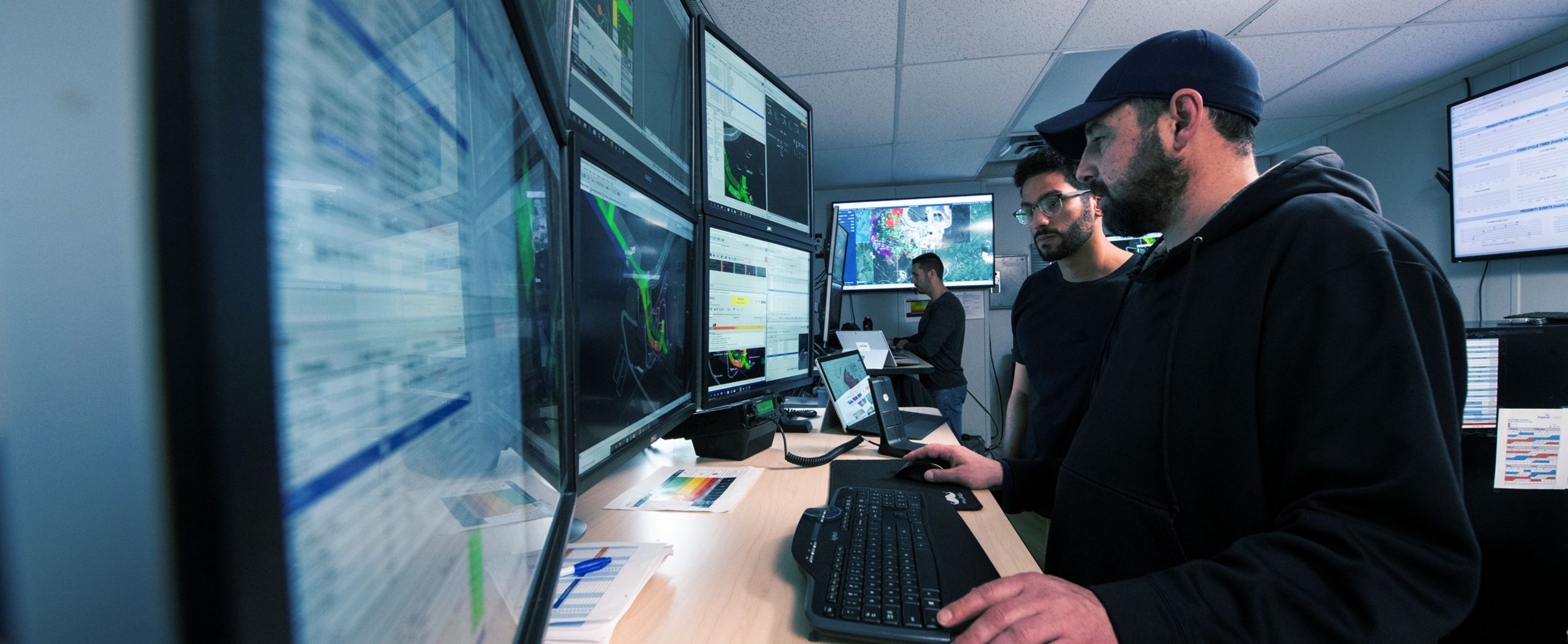 Two men looking at multiple monitors