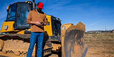 construction worker looking at cell phone in hand