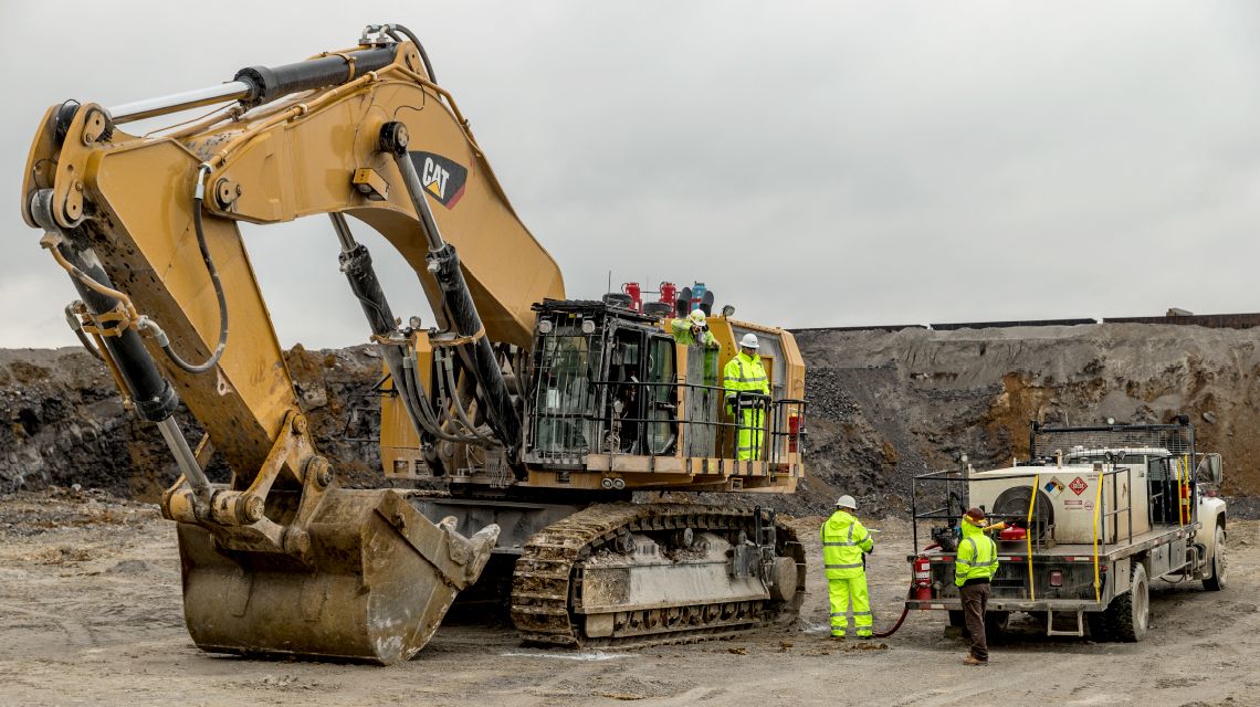 Team performing service on a Cat excavator