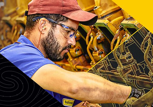 A Cat dealer service technician working on a Cat engine