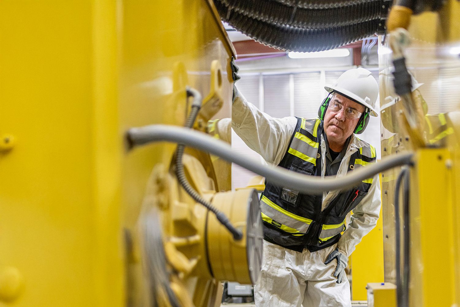 A Caterpillar employee inspecting a machine