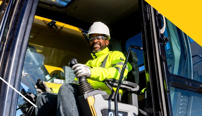 a construction professional smiling while operating a material handler